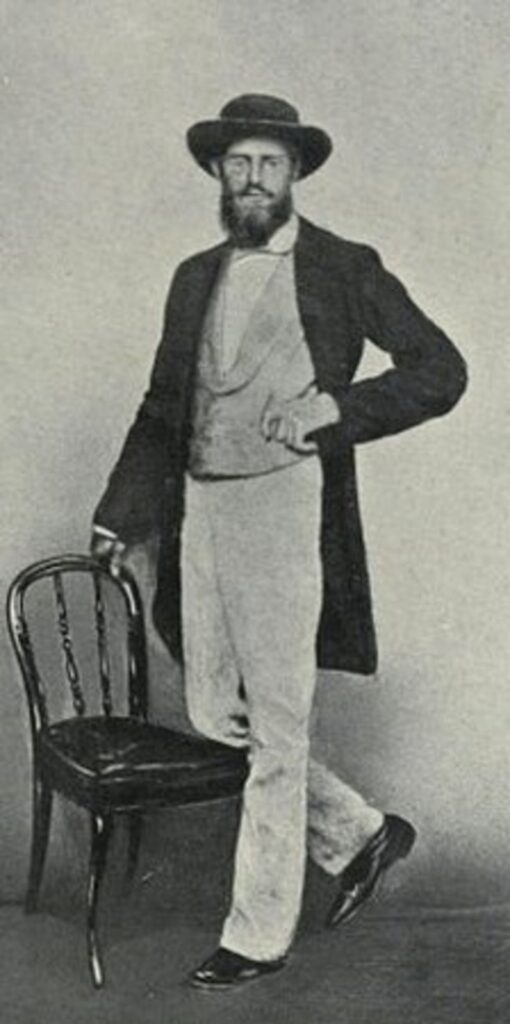 Wallace standing with one knee on a chair
